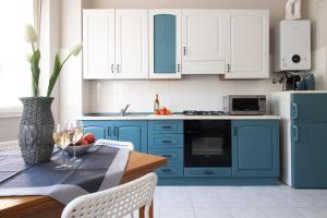 a kitchen with blue cabinets and a table with a vase at Happy Home in Saronno