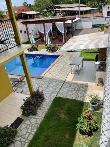 eine Terrasse mit einem Pool, einem Tisch und Blumen in der Unterkunft Casa Boto Tucuxi 2 in Novo Airão