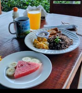 a table with two plates of food and a drink at Hotel Cabinas Murillo in Drake