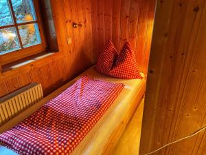 Cabaña con 2 almohadas rojas y blancas en un banco en Ferienhaus Falbeson en Neustift im Stubaital