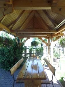 a wooden picnic table under a wooden roof at Noclegi u Danuty in Groń