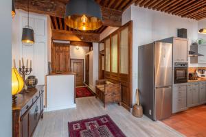 a kitchen with a stainless steel refrigerator and wooden ceilings at LES SUITES D'ANNICIACA - Hyper centre avec vue sur le chateau in Annecy