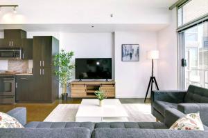 卡尔加里Stylish 1BR, Stampede & Free Parking by Doorbed的客厅里有一张沙发和一台电视