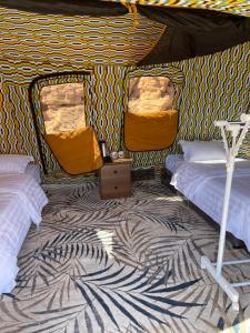 a room with two beds in a tent at Rural tents Naseem الخيمةالريفيةAlouzaib in Al Ula
