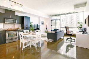 a kitchen and living room with a table and chairs at Stylish 1BR, Stampede & Free Parking by Doorbed in Calgary