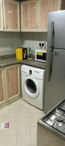 a kitchen with a washing machine and a refrigerator at بناية يا هلا in Ajman 