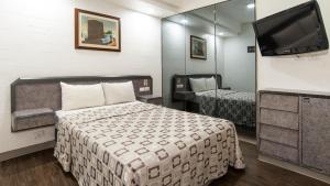Habitación pequeña con cama y TV. en Hotel Unico en Ciudad de México