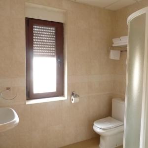 a bathroom with a toilet and a window at Hostal Mirador de Avila in Avila