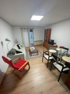 een woonkamer met een bank en een tafel en stoelen bij San Pablo, piso céntrico in Palencia