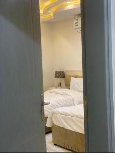 a door open to a bedroom with two beds at المغتره للشقق الفندقيه in Ad Dawādimī