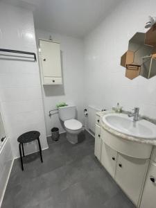 a white bathroom with a toilet and a sink at San Pablo, piso céntrico in Palencia