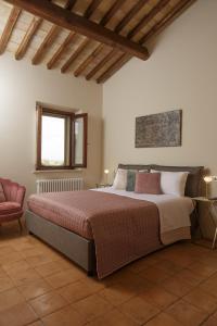1 dormitorio con 1 cama grande y 1 silla en SeiPetali, en Cannara