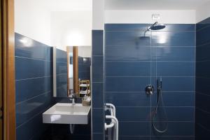 a blue bathroom with a sink and a shower at SeiPetali in Cannara