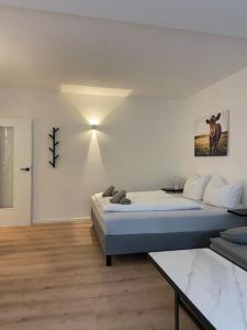 a white room with a bed and a table at Exklusives Apartment mit Schwimmbad im Allgäu in Oy-Mittelberg