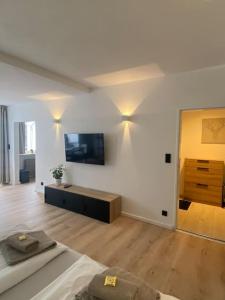 a room with a bed and a tv on a wall at Exklusives Apartment mit Schwimmbad im Allgäu in Oy-Mittelberg +28 photos