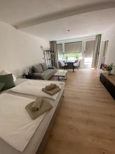 ein Schlafzimmer mit einem großen Bett und ein Wohnzimmer in der Unterkunft Exklusives Apartment mit Schwimmbad im Allgäu in Oy-Mittelberg