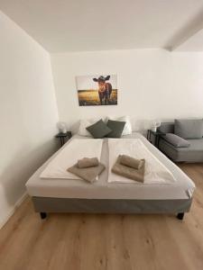 a white bedroom with a bed and a couch at Exklusives Apartment mit Schwimmbad im Allgäu in Oy-Mittelberg