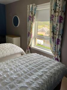 una camera con letto e finestra con tende di Home from home, 3 bedroom house in Hawick a Hawick