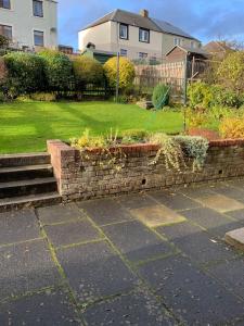 a brick retaining wall with plants in a yard at Home from home, 3 bedroom house in Hawick in Hawick
