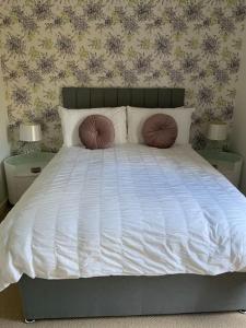 a bedroom with a white bed with two pillows at Home from home, 3 bedroom house in Hawick in Hawick