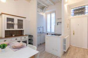 uma cozinha com armários brancos e uma mesa branca com uma mesa em [New flat] Crocetta 2 em Milão