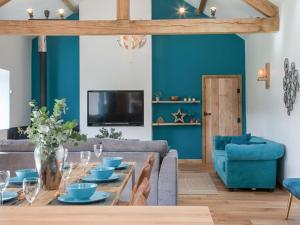 a living room with a table and a couch at The Pendre Longbarn in Pentre-briwnant