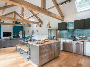 una cocina con electrodomésticos de acero inoxidable y azulejos azules en The Pendre Longbarn en Pentre-briwnant