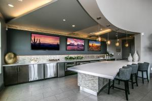 una cocina con una gran isla blanca con sillas en Rooftop Pool - Golf, Shopping & Dining 2 Miles wtih Parking - 4404, en Scottsdale