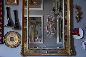 un espejo de oro ornamentado colgando de una pared en Residenza Vespucci, en Florencia
