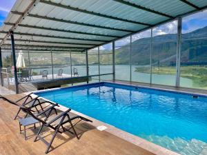 una piscina con vistas al lago y a las montañas en El Balcon de los Reyes en Ibarra