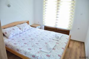 a bedroom with a bed with two towels on it at Apartman Sofija in Kaludjerske Bare