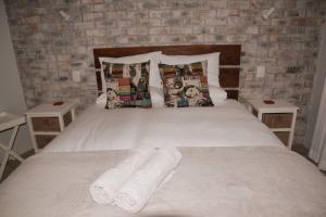 una camera da letto con un letto e due asciugamani di Apt on Beach front, Modern 2BR Solar, 50m to beach a Strandfontein