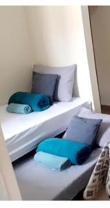 two twin beds with blue pillows on them at kitnet completa no Centro in Carolina