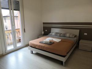 een slaapkamer met een bed en een groot raam bij B&B Matteotti 23 in Bologna