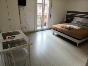 ein Schlafzimmer mit einem Bett und einem Tisch und einem Fenster in der Unterkunft B&B Matteotti 23 in Bologna + 9 Fotos