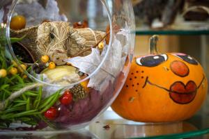 a glass vase filled with fruit and vegetables next to a pumpkin at Flamingo Grand Hotel & Spa in Albena