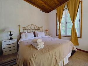 a bedroom with a bed with towels on it at Posada Don Salvador in San Antonio de Areco