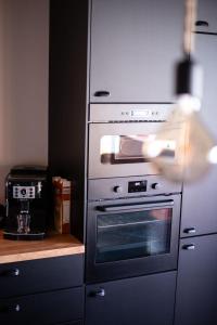 een keuken met roestvrijstalen ovens en een aanrecht bij Le Refuge de Maïly in Beauraing