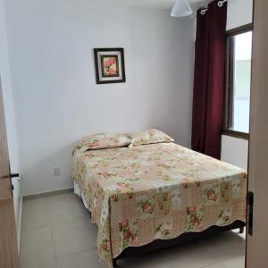 um pequeno quarto com uma cama com um cobertor em Condominio Frente do mar! Lindo apartamento! em Florianópolis