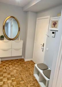 baño con espejo y puerta blanca en Apartamento con garaje a un paso de la playa, en Gijón
