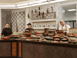 a group of people preparing food in a kitchen at Esperos Palace Resort in Faliraki