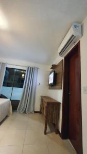 een kamer met een bed, een tv en een raam bij Aparts da Praia Grande 79 in Arraial do Cabo