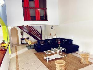 a living room with a blue couch and a table at Résidence chez Adine in Sainte-Anne
