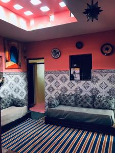 a room with two beds and a red wall at Cap sim surf house in Essaouira