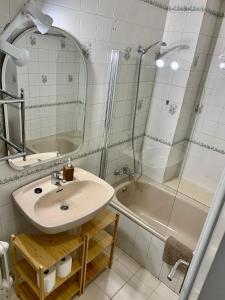 een badkamer met een wastafel, een douche en een bad bij Apartamento con garaje a un paso de la playa in Gijón