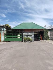 a building with a green roof and a parking lot at HOTEL PARQUE en Merlo- Buenos Aires in Merlo