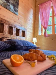 a cutting board with an orange on a bed at Wooden house with a waterfall "Stipanov mlin" in Plitvička Jezera