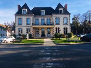une grande maison avec une voiture garée devant elle dans l'établissement Appart Hôtel 3* dans une résidence de tourisme, à Le Mée-sur-Seine