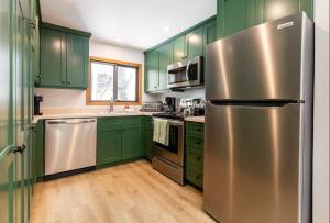 uma cozinha com armários verdes e um frigorífico de aço inoxidável em Spacious 3 bedroom townhouse with tennis courts em Vail
