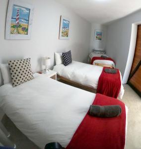 a small bedroom with two beds and a couch at Apt on Beach front, Modern 2BR Solar, 50m to beach in Strandfontein